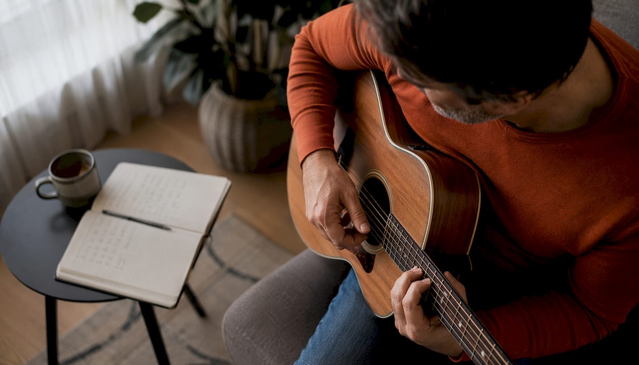 In de studio schuiven vingers soepel over de snaren terwijl er van akkoord gewisseld wordt op de gitaar.