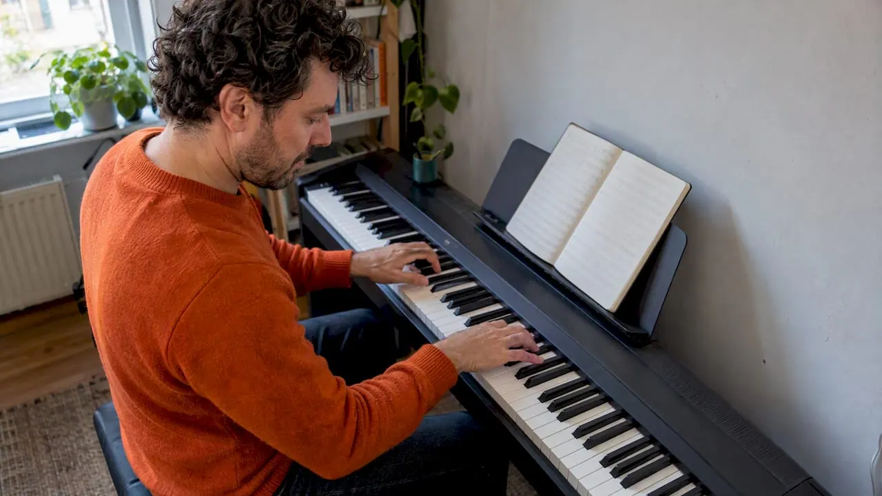 Een cursist probeert een zelfgeschreven melodie uit op de piano