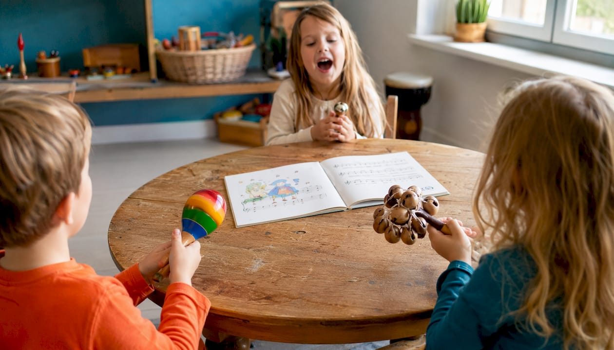 Van dichtbij zie je kinderen enthousiast spelen met een tamboerijn en klankstaven.