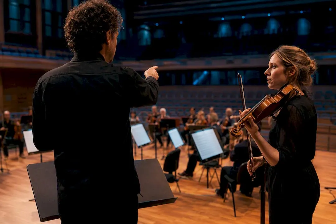 Dirigent bespreekt een cue met de concertmeester