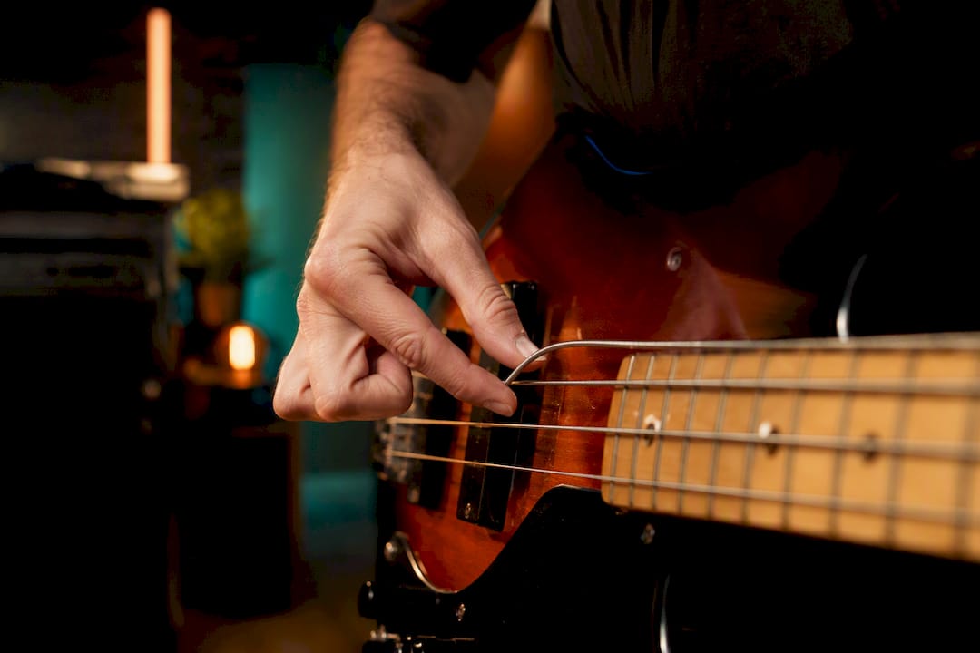 Bassist die een bas snaar met vinger popt